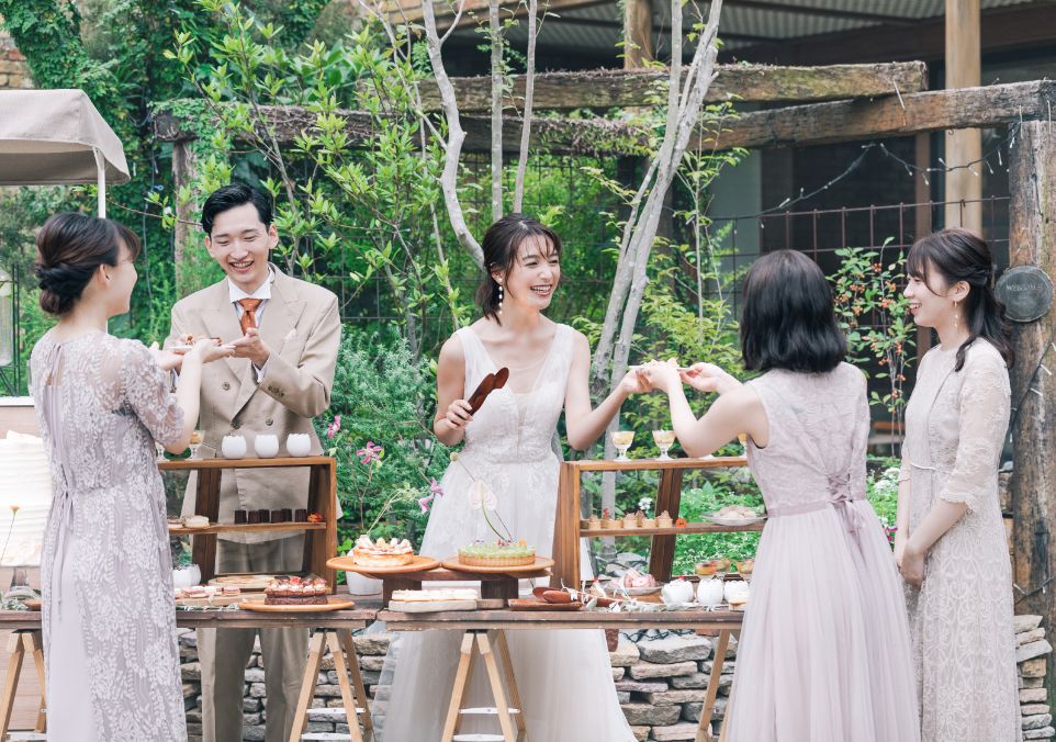 庭でデザートビュッフェを取り分ける新郎新婦と受け取るゲスト