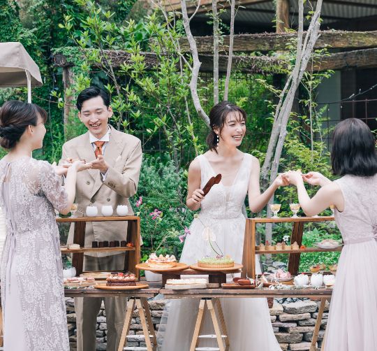 庭でデザートビュッフェを取り分ける新郎新婦と受け取るゲスト