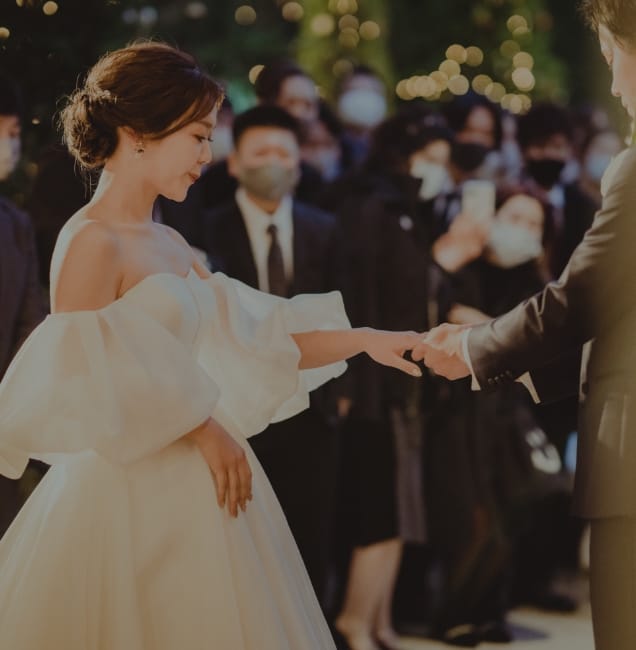 挙式中の新郎に手を添えられている新婦