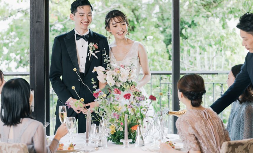 窓際でゲストと話をする新郎新婦