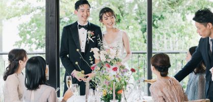 窓際でゲストと話をする新郎新婦