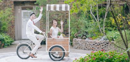ガーデン入場で自転車にのって手をふる新郎新婦