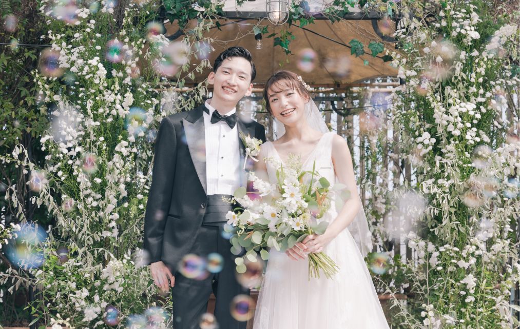 シャボン玉シャワーの中で笑顔の新郎新婦