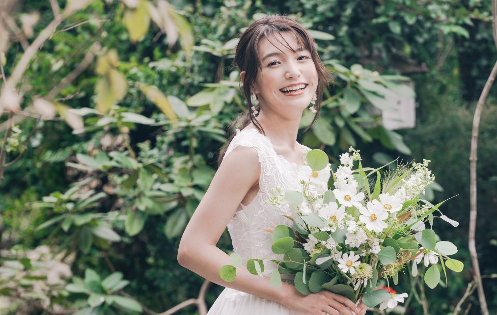 グリーンベースのブーケと笑顔の新婦