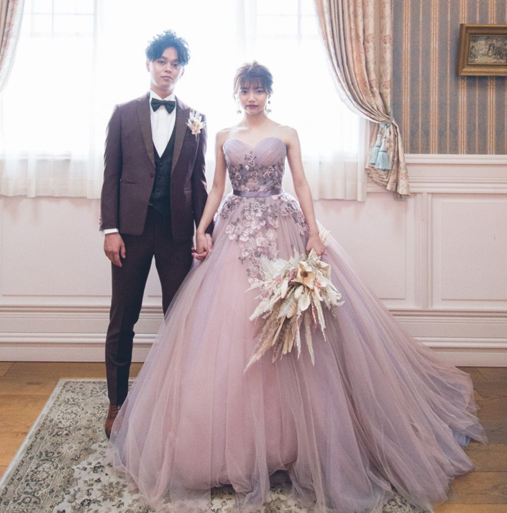 ラベンダーのカラードレスと茶色のタキシードの新郎新婦