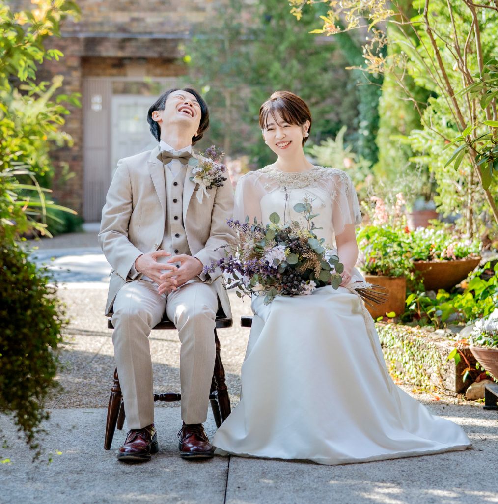 ローブのあるウエディングドレスとベージュのスーツの新郎新婦