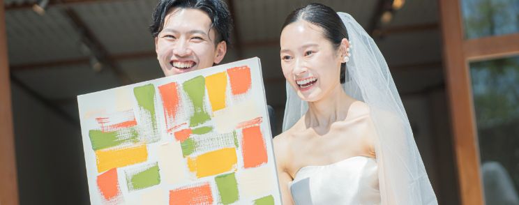 人前式でパネルを見せる笑顔の新郎新婦