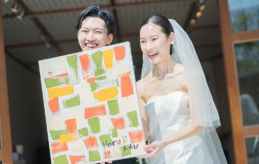 人前式でパネルを見せる笑顔の新郎新婦